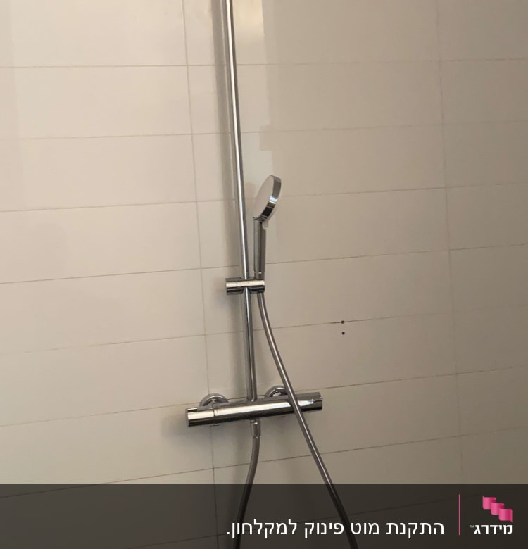 ראש מקלחת וכיור בחדר אמבטיה